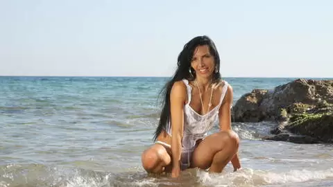 Bettina Kox haciendo un strip  al lado del mar  